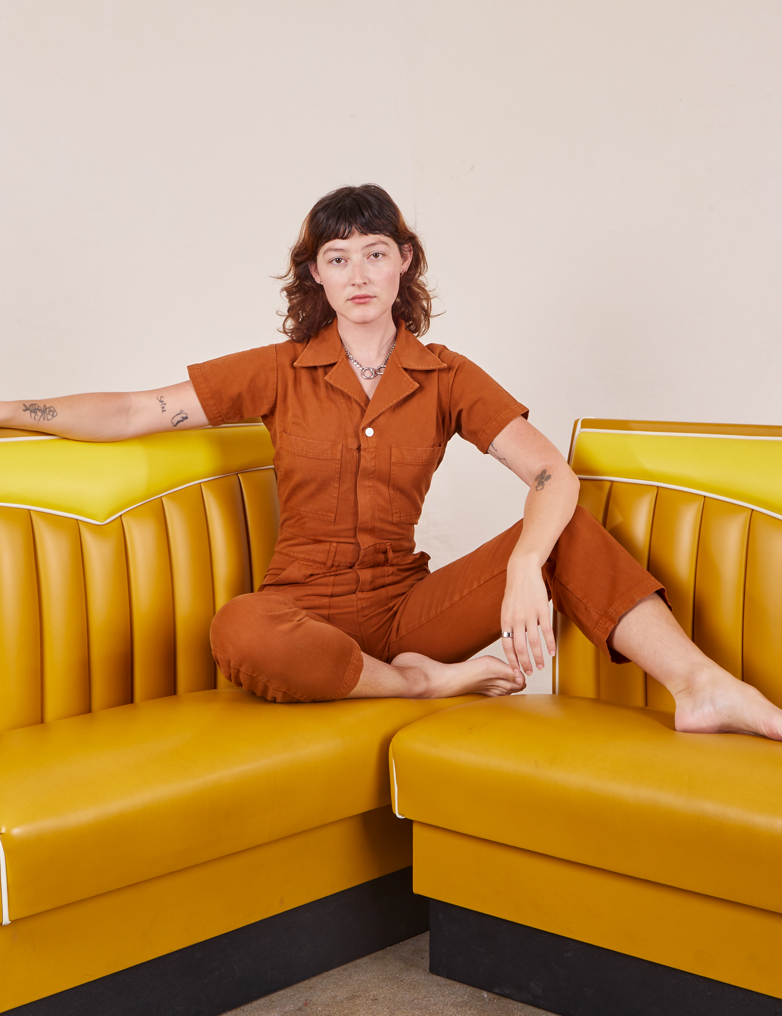 Alex is wearing Short Sleeve Jumpsuit in Burnt Terracotta
