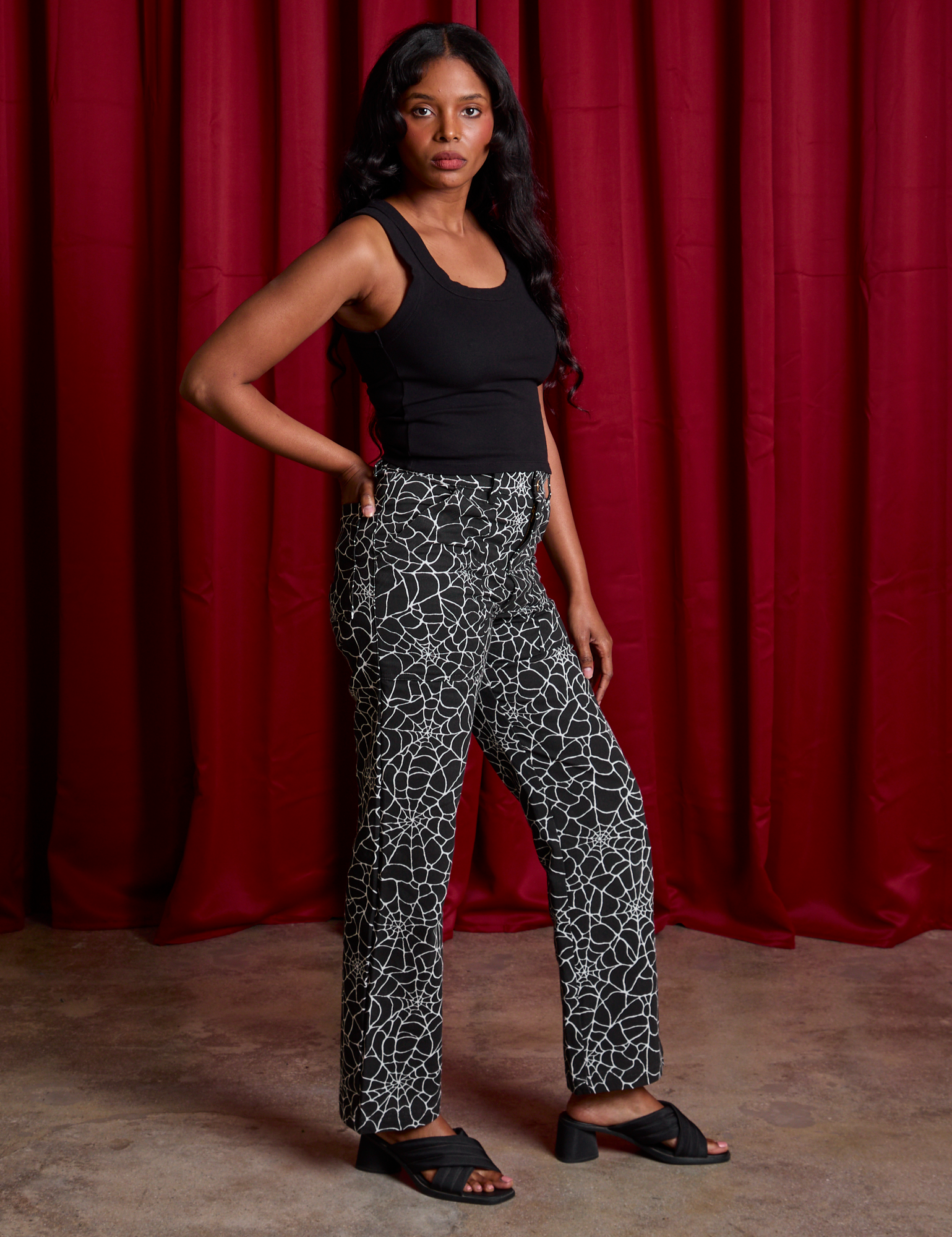 Side view of Work Pants in Spiderwebs and black Cropped Tank on Kandia