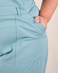 Short Sleeve Jumpsuit in Baby Blue front pocket close up. Juliet has her hand in the pocket.