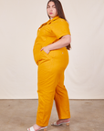 Side view of Short Sleeve Jumpsuit in Mustard Yellow worn by Marielena
