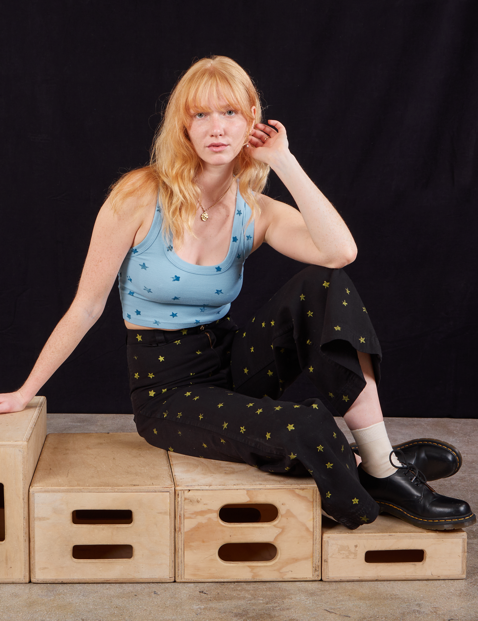 Margaret is wearing Star Bell Bottoms in Black and Star Cropped Tank in blue