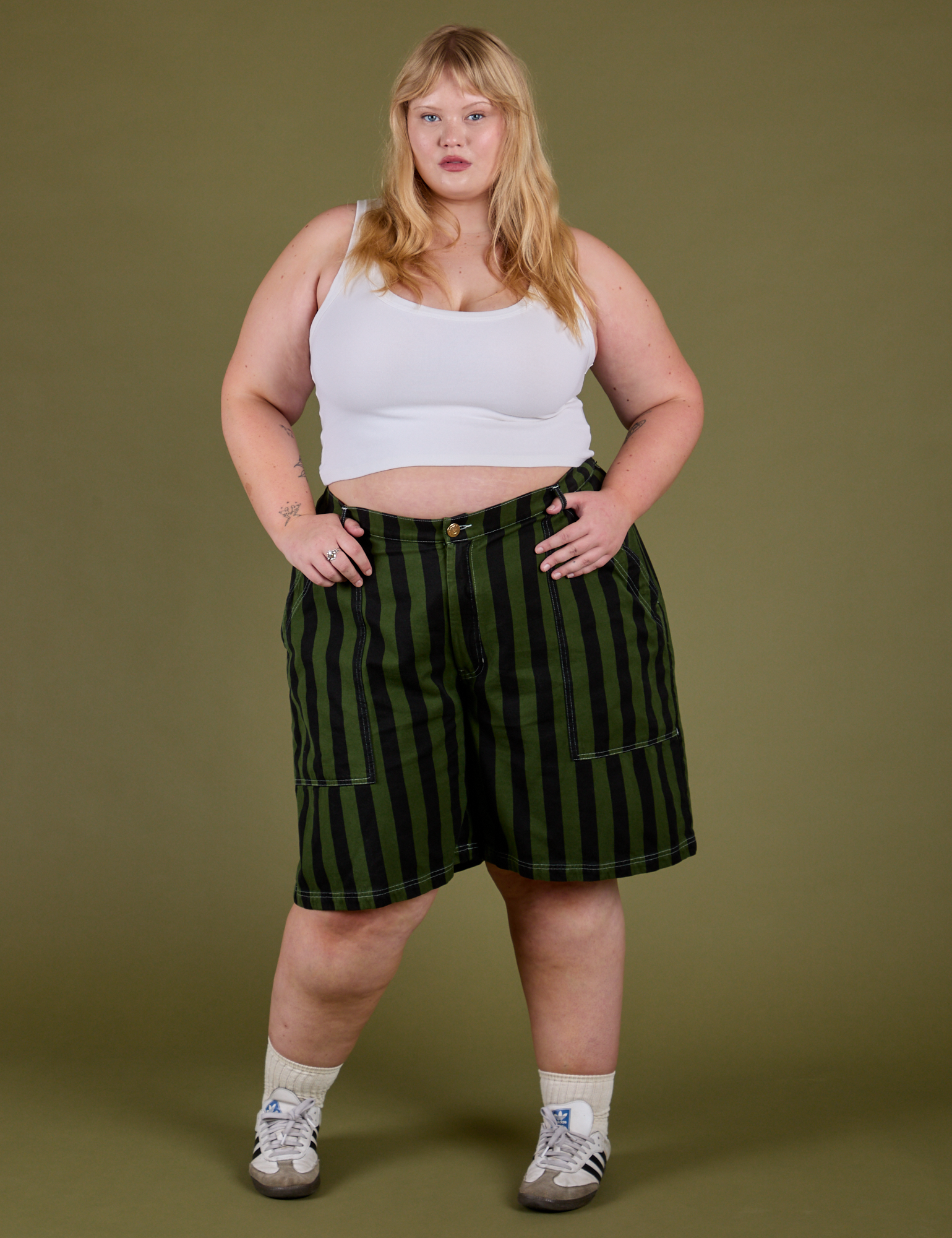 Juliet is 5’7” and wearing 2XL Longline Work Shorts in Evergreen paired with a Cropped Tank in Vintage Tee White