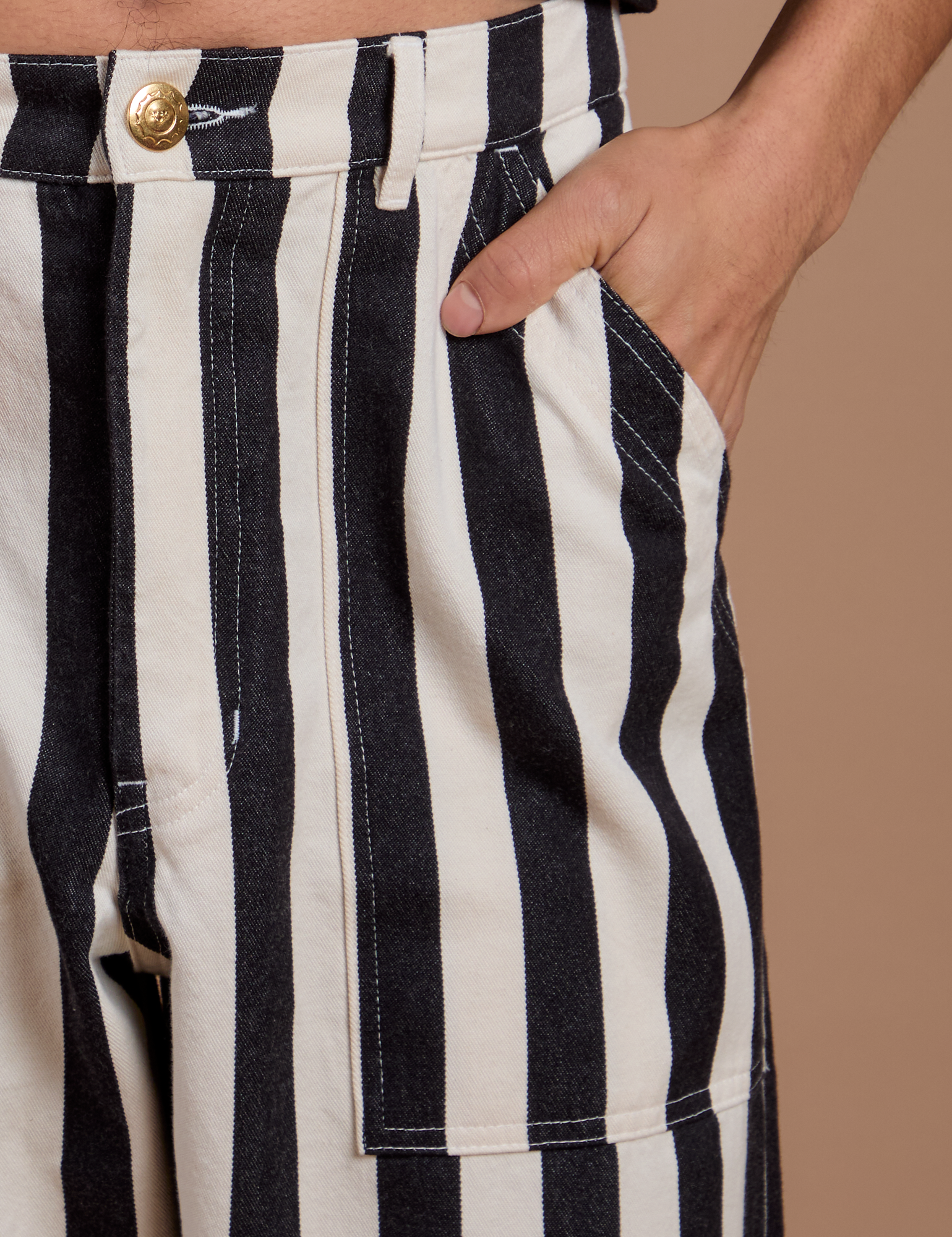 Close up of Anthony's hand in the front pocket of Black Stripe Work Pants in White