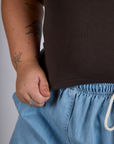 Close up of Juliet holding The Tank Top in Espresso Brown bottom hem