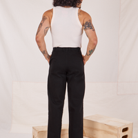 Back view of Denim Trouser Jeans in Black and vintage off-white Tank Top worn by Jesse