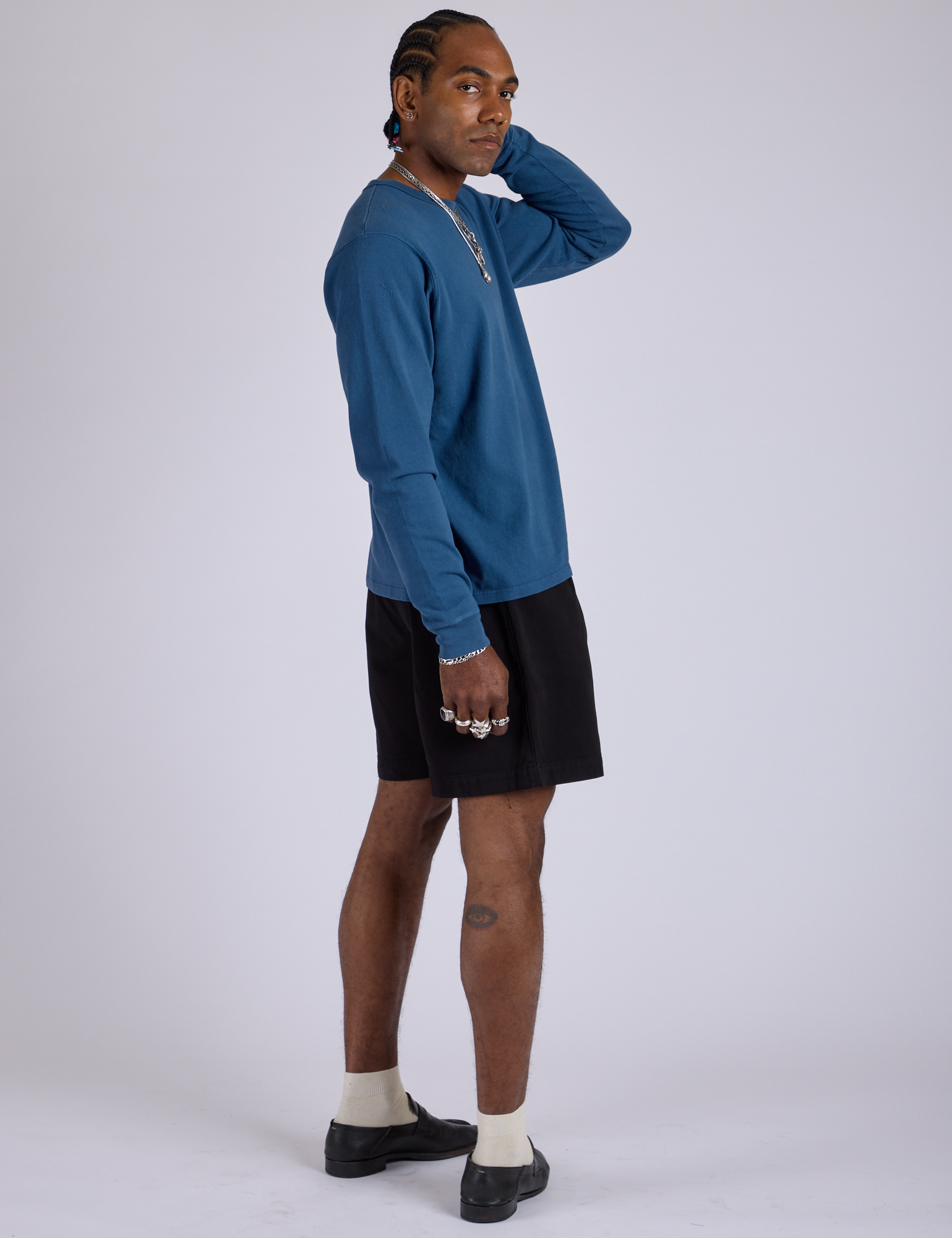 Side view of Pleated Trouser Shorts in Basic Black paired with Long Sleeve Burly Tee in French Blue on Jerrod