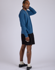 Side view of Pleated Trouser Shorts in Basic Black paired with Long Sleeve Burly Tee in French Blue on Jerrod