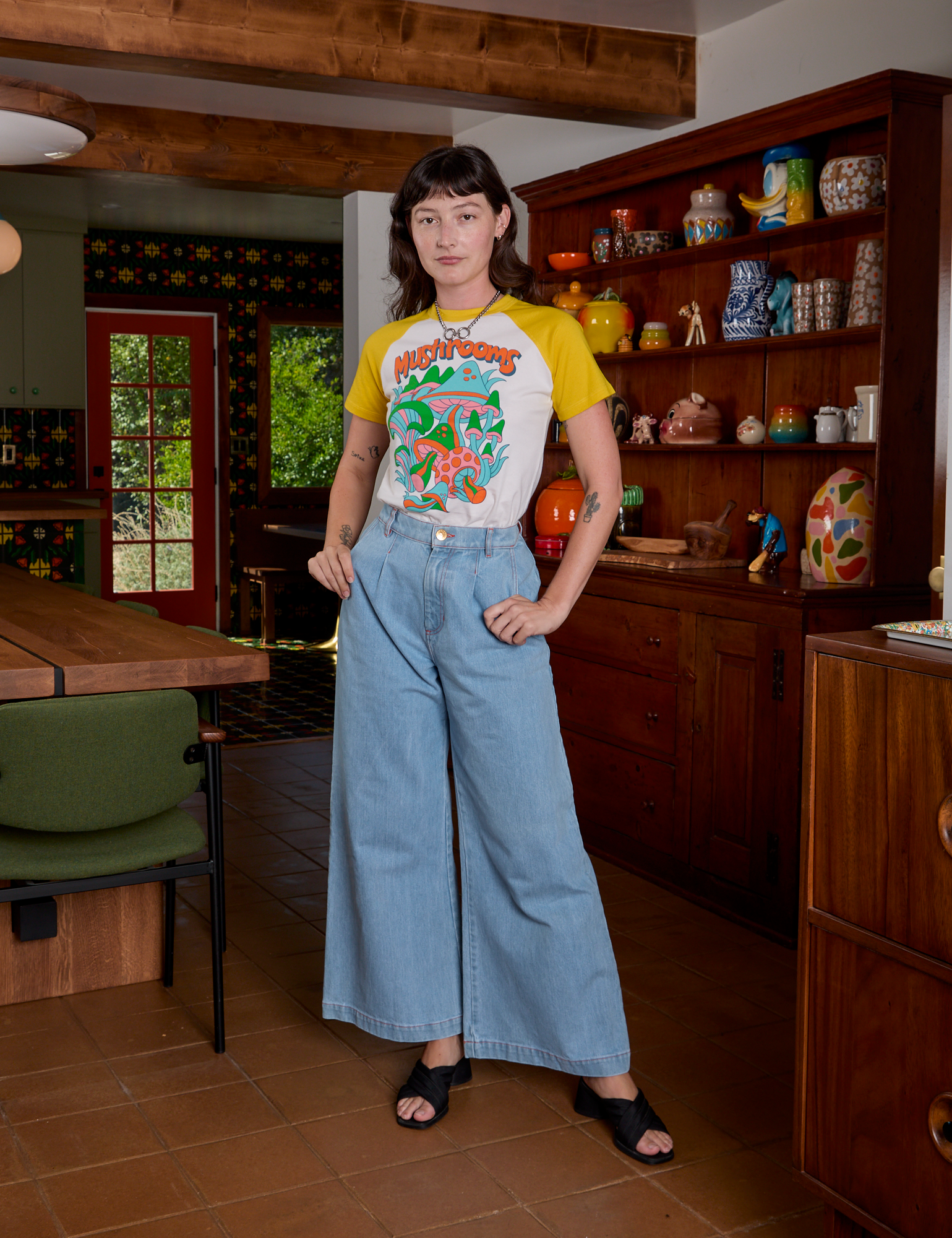 Alex is wearing Short Sleeve Raglan Tee in Mushrooms tucked into light wash Indigo Wide Leg Trousers