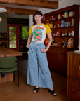 Alex is wearing Short Sleeve Raglan Tee in Mushrooms tucked into light wash Indigo Wide Leg Trousers