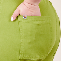 Back pocket close up of Western Pants in Gross Green. Worn by Ashley with her hand in the pocket.