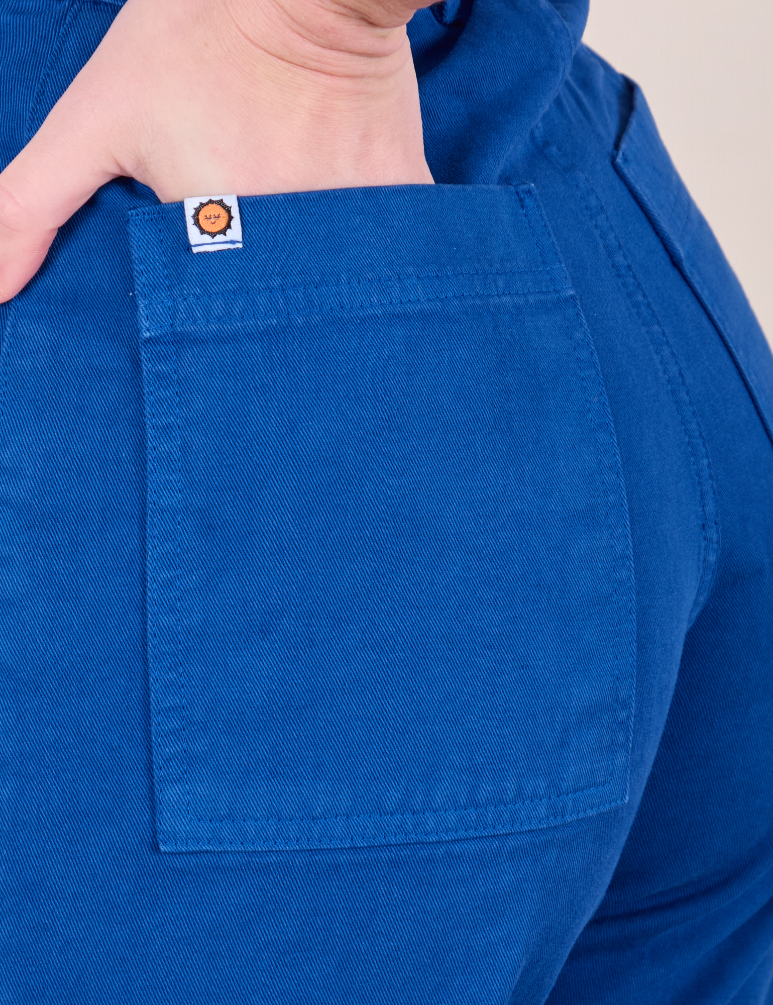 Close up of Alex&#39;s hand in the back pocket of Western Pants in Royal Blue