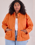 Morgan is 5'5" and wearing 1XL Denim Work Jacket in Construction Orange