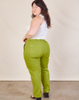 Angled back view of Work Pants in Gross Green and Cropped Tank in vintage tee off-white on Ashley