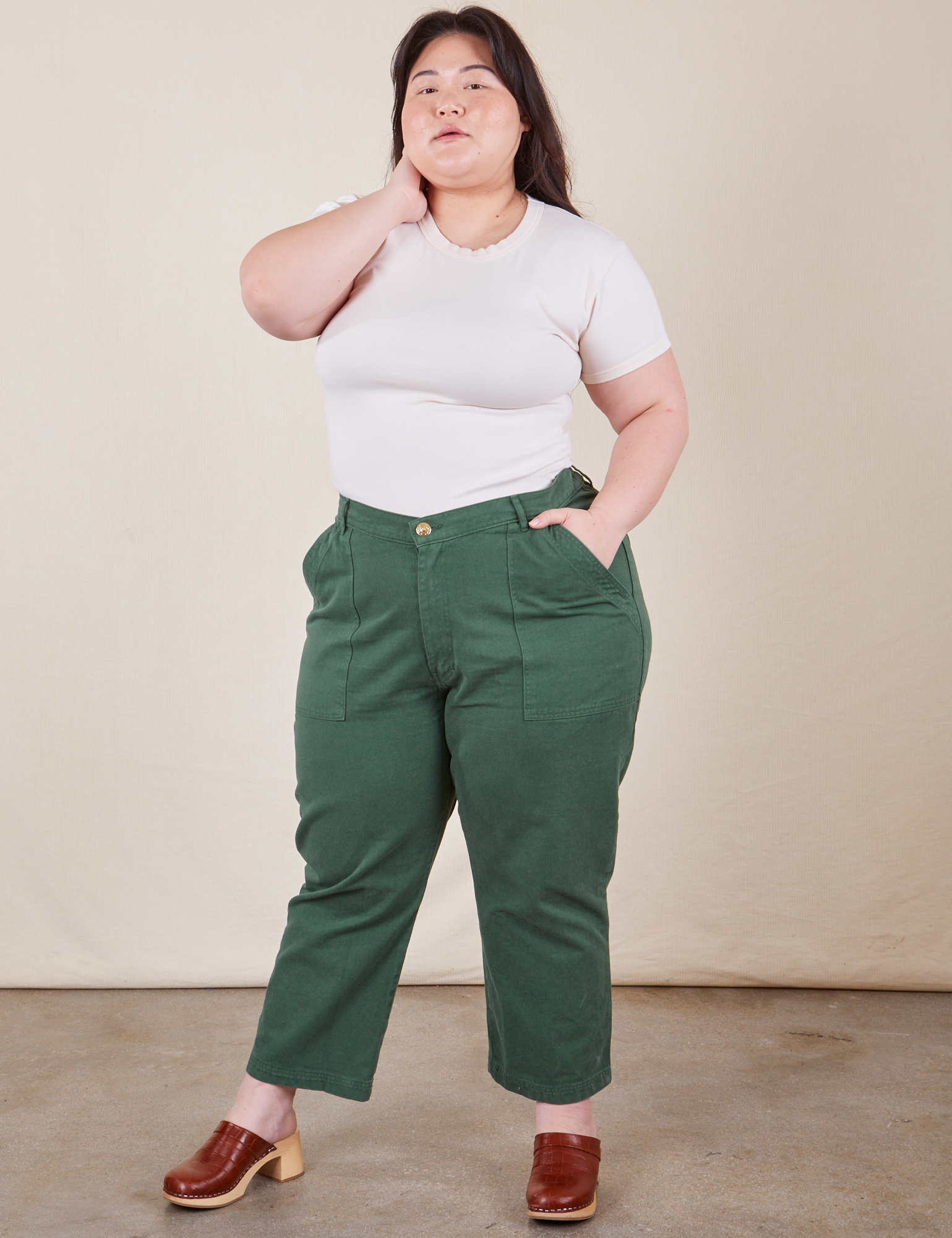 Ashley is 5&#39;7&quot; and wearing Petite 1XL Work Pants in Dark Emerald Green paired with vintage off-white Baby Tee