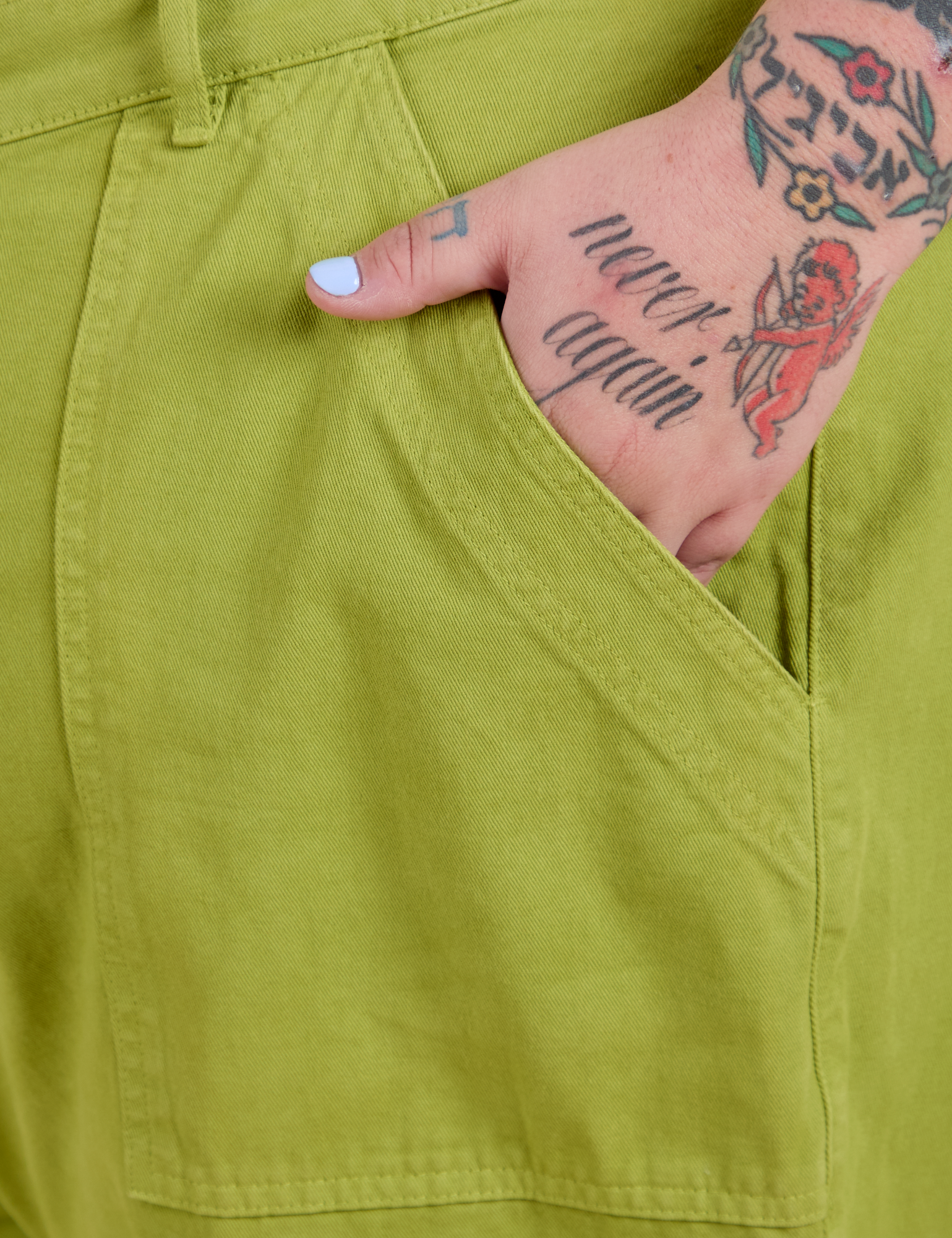 Close up of Sam's hand in the front pocket of Work Pants in Gross Green