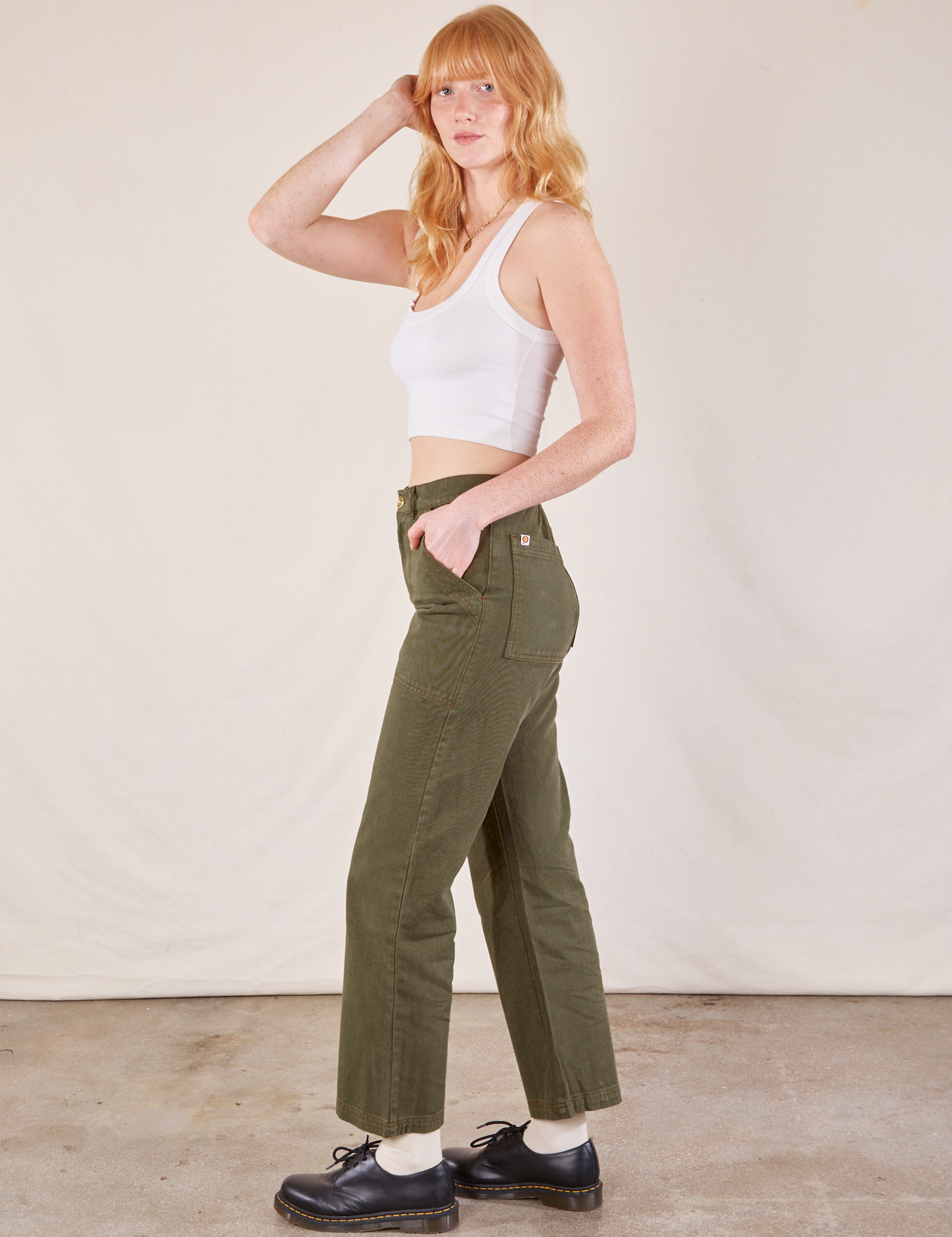 Side view of Work Pants in Surplus Green and Cropped Tank in vintage tee off-white on Margaret