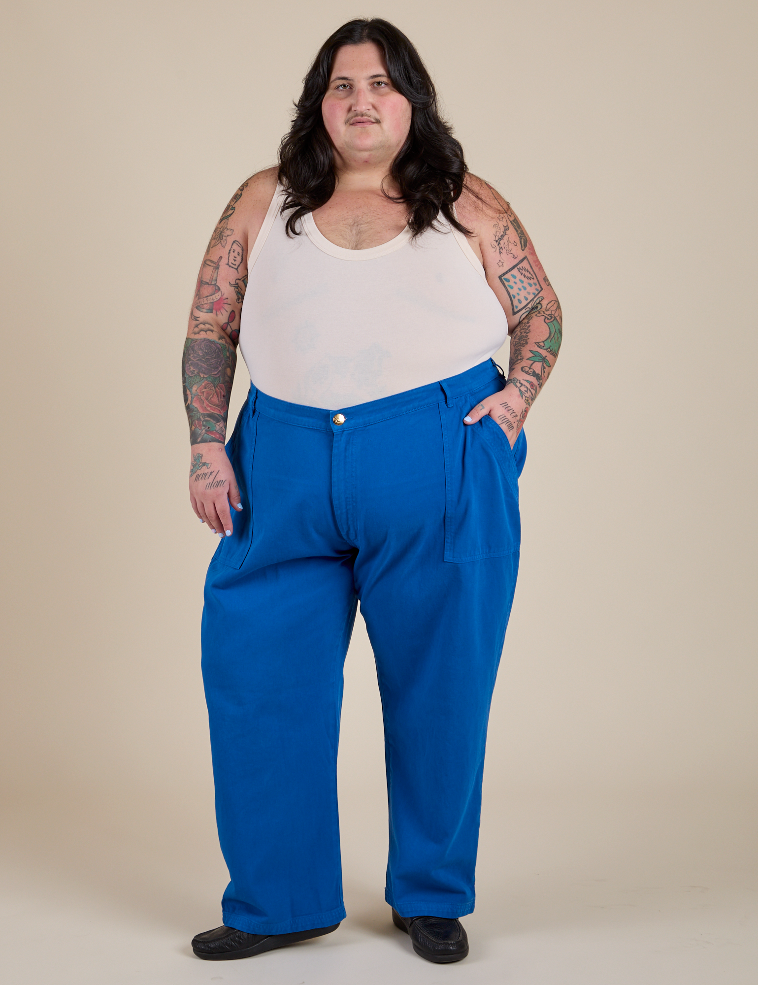 Sam is 5’10” and wearing 4XL Work Pants in Royal Blue paired with a vintage tee off-white Tank Top