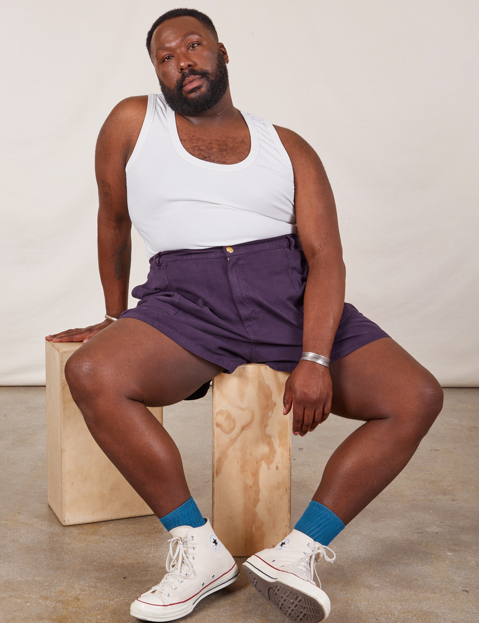 Elijah is wearing Classic Work Shorts in Nebula Purple and a Tank Top in vintage tee off-white