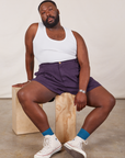 Elijah is wearing Classic Work Shorts in Nebula Purple and a Tank Top in vintage tee off-white
