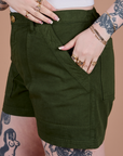 Close up of Sydney's hand in the front pocket of Classic Work Shorts in Evergreen