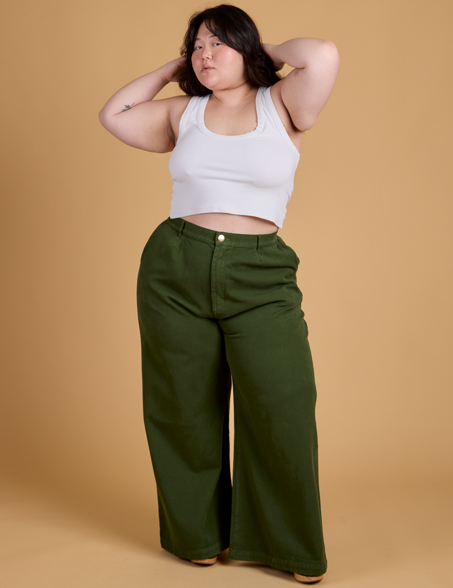 Ashley is 5&#39;7&quot; and wearing 1XL Heritage Wide Leg Trousers in Evergreen paired with vintage tee white Cropped Tank