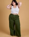 Ashley is 5'7" and wearing 1XL Heritage Wide Leg Trousers in Evergreen paired with vintage tee white Cropped Tank