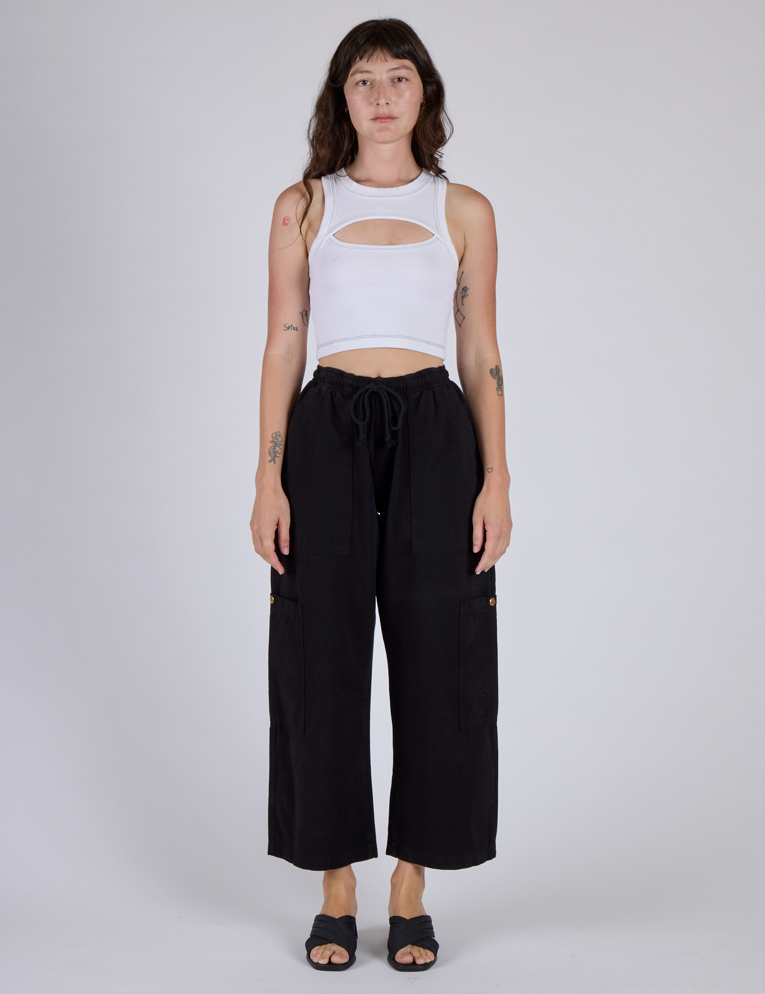 Alex is wearing the Vintage Tee White Porthole Tank with Black Cargo Pants