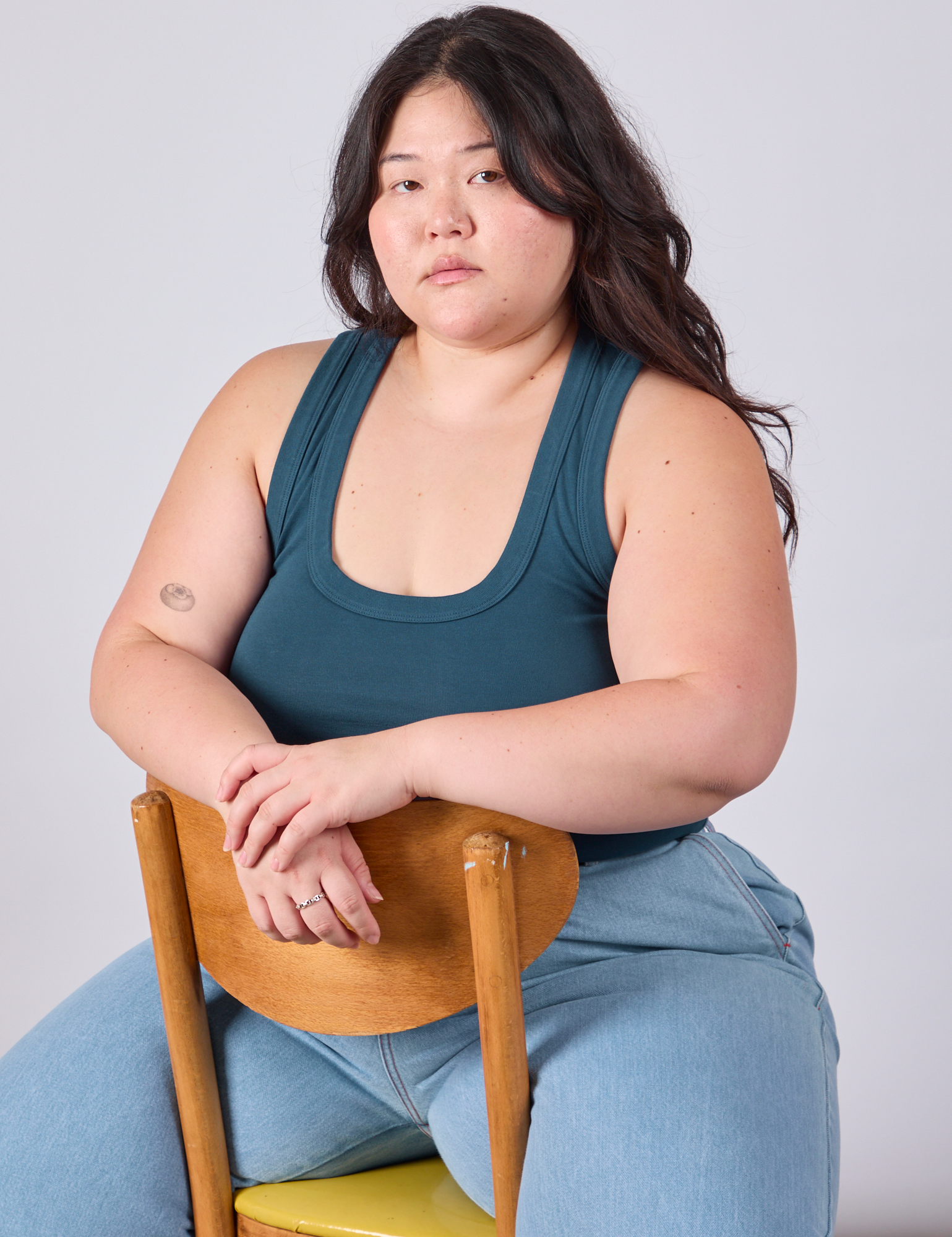 Ashley is wearing Cropped Tank Top in Lagoon and sitting in a chair