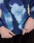 Long Sleeve Baby Tee in Blue Magic Waters bottom close up with Alex holding the hem