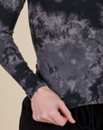 Long Sleeve Baby Tee in Black Magic Waters bottom close up with Alex holding the hem