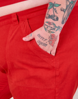 Close up of Sam's hand in the front pocket of Mid-Rise Work Pants in Mustang Red