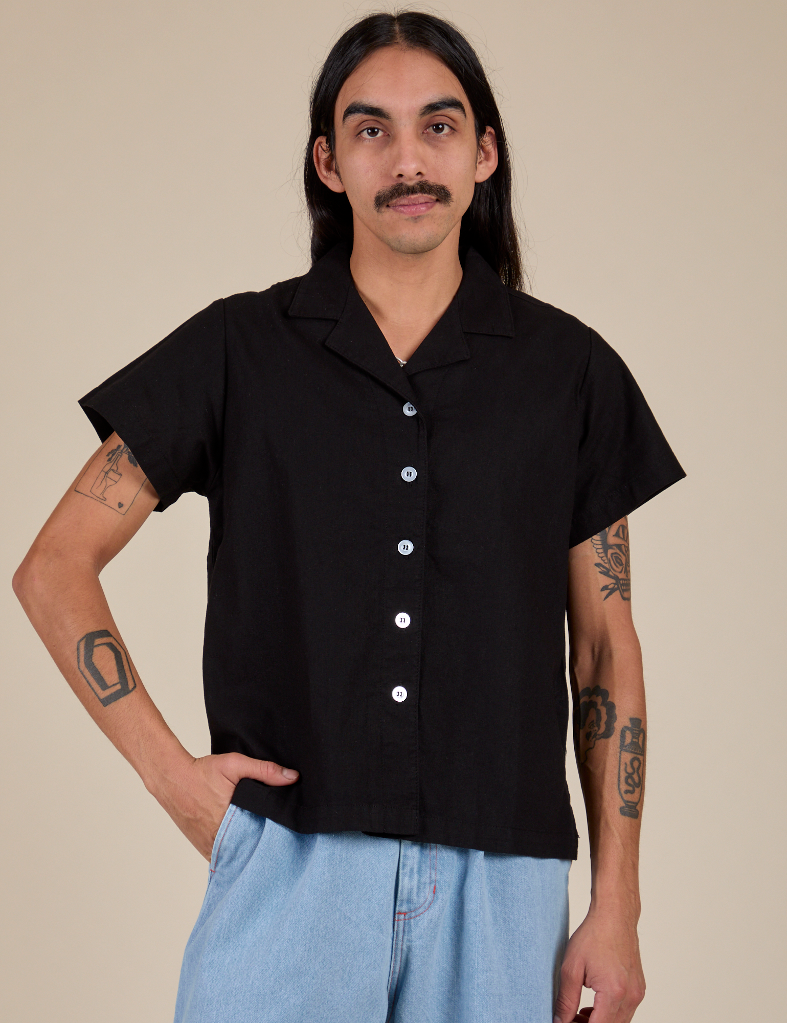 Anthony is wearing a buttoned up Pantry Button-Up in Basic Black