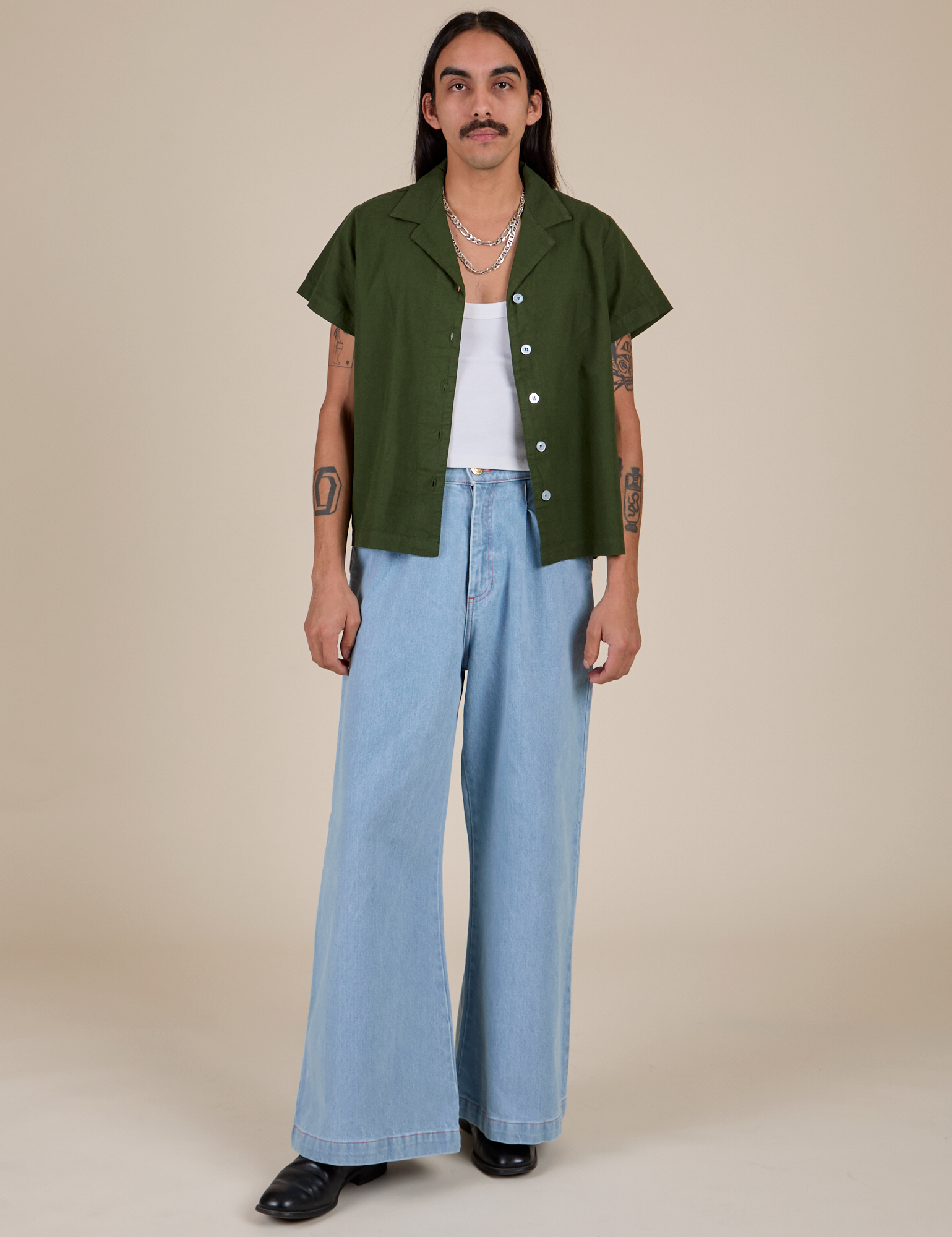 Anthony is wearing Pantry Button-Up in Evergreen and light wash Indigo Wide Leg Trousers