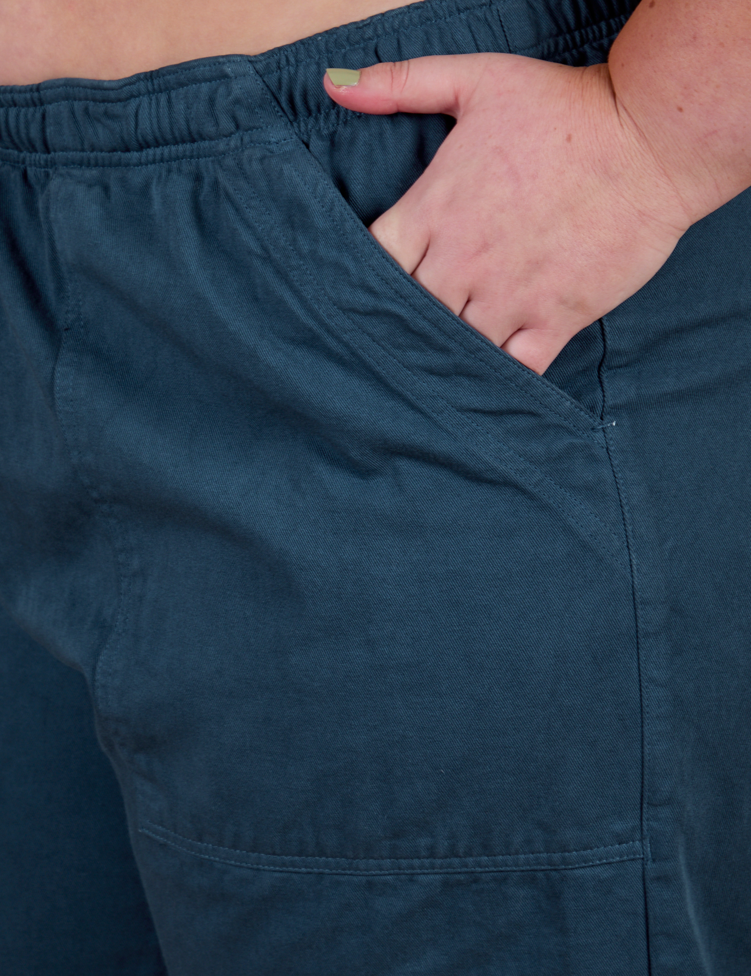 Close up of Juliet's hand in the front pocket of Action Pants in Lagoon