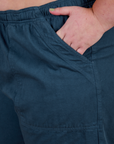 Close up of Juliet's hand in the front pocket of Action Pants in Lagoon