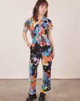 Hana is wearing Petite Short Sleeve Jumpsuit in Rainbow Magic Waters