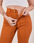 Pencil Pants in Burnt Terracotta front close up. Alex is holding the zipper tab