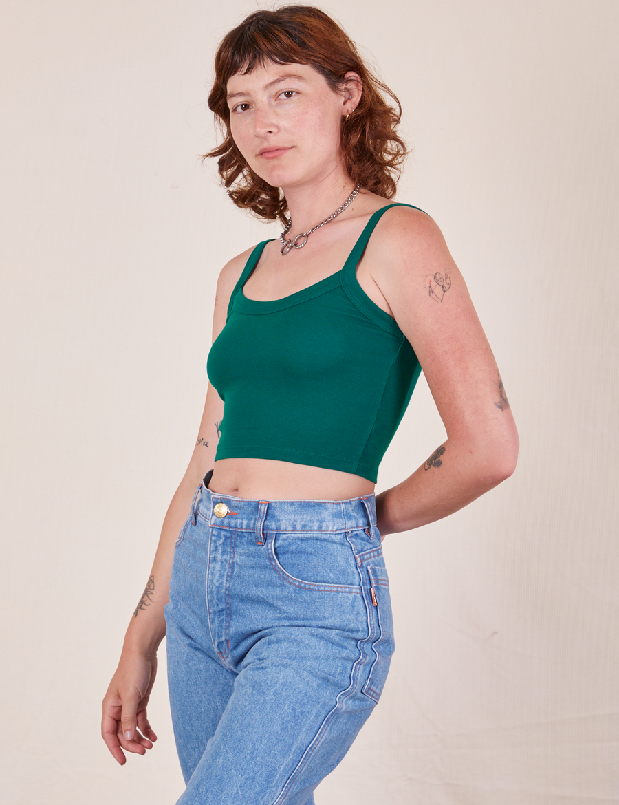 Angled view of Cropped Cami in Hunter Green and light wash Frontier Jeans worn by Alex
