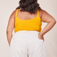 Back view of Cropped Cami in Sunshine Yellow and vintage off-white Western Pants worn by Alicia. She has her left hand in the back pant pocket.