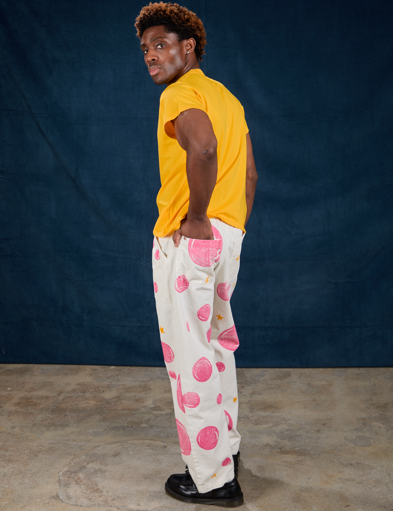 Side view of Paintstamped Work Pants in Bubblegum and sunshine yellow Organic Vintage Tee