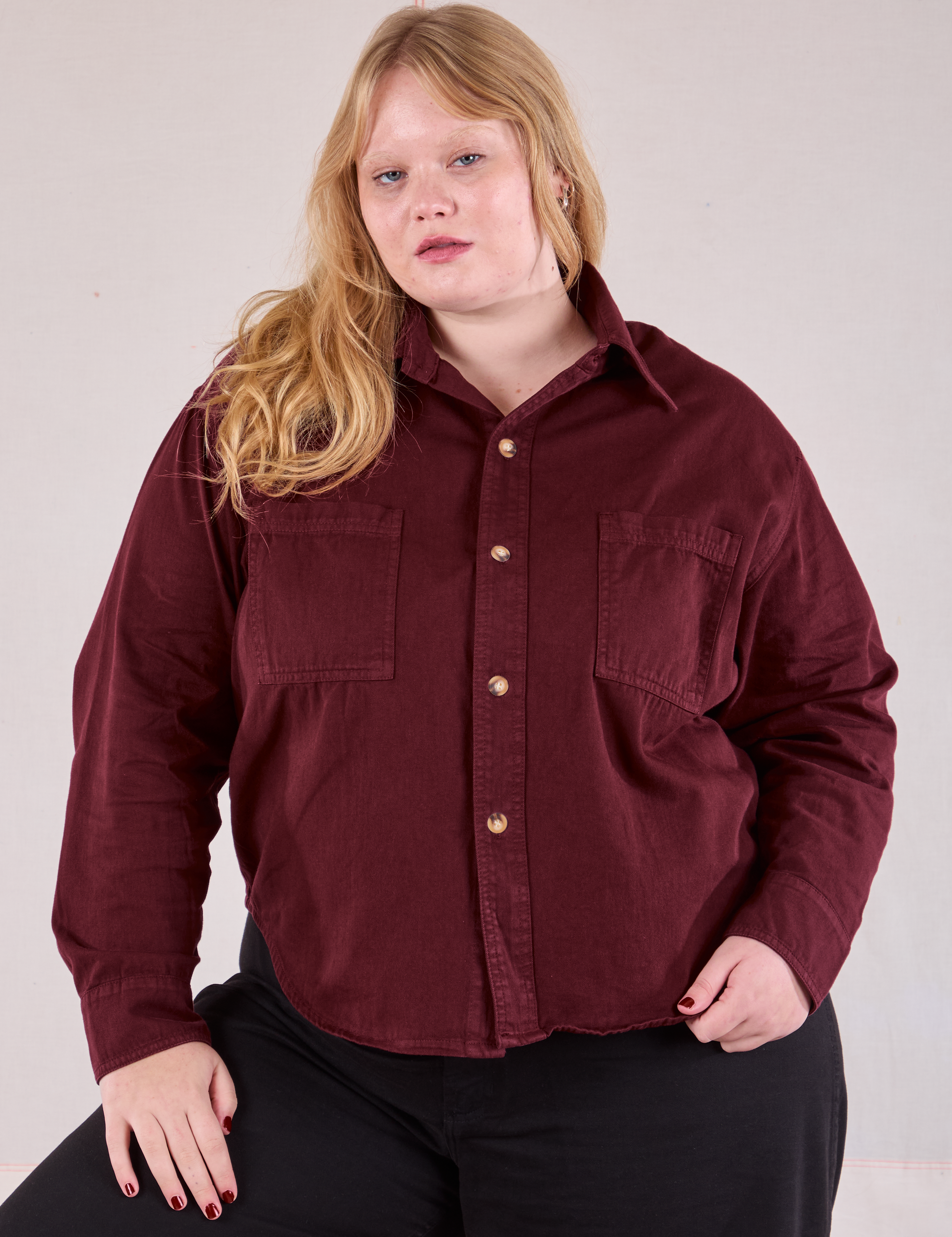 Juliet is wearing a buttoned up Cropped Overshirt in Red Wine