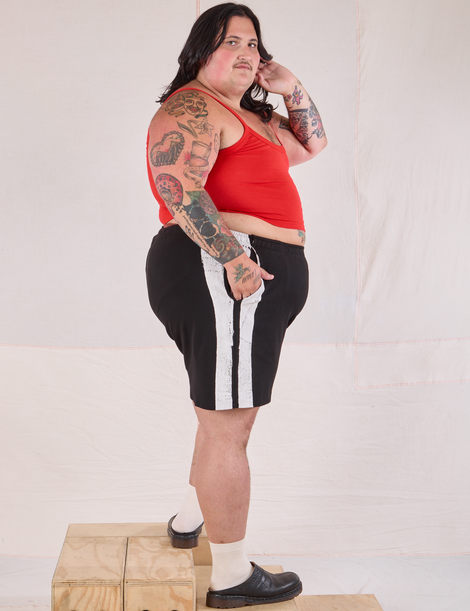 Side view of Painted Stripe Easy Shorts in Basic Black and Cropped Cami in Mustang Red on Sam