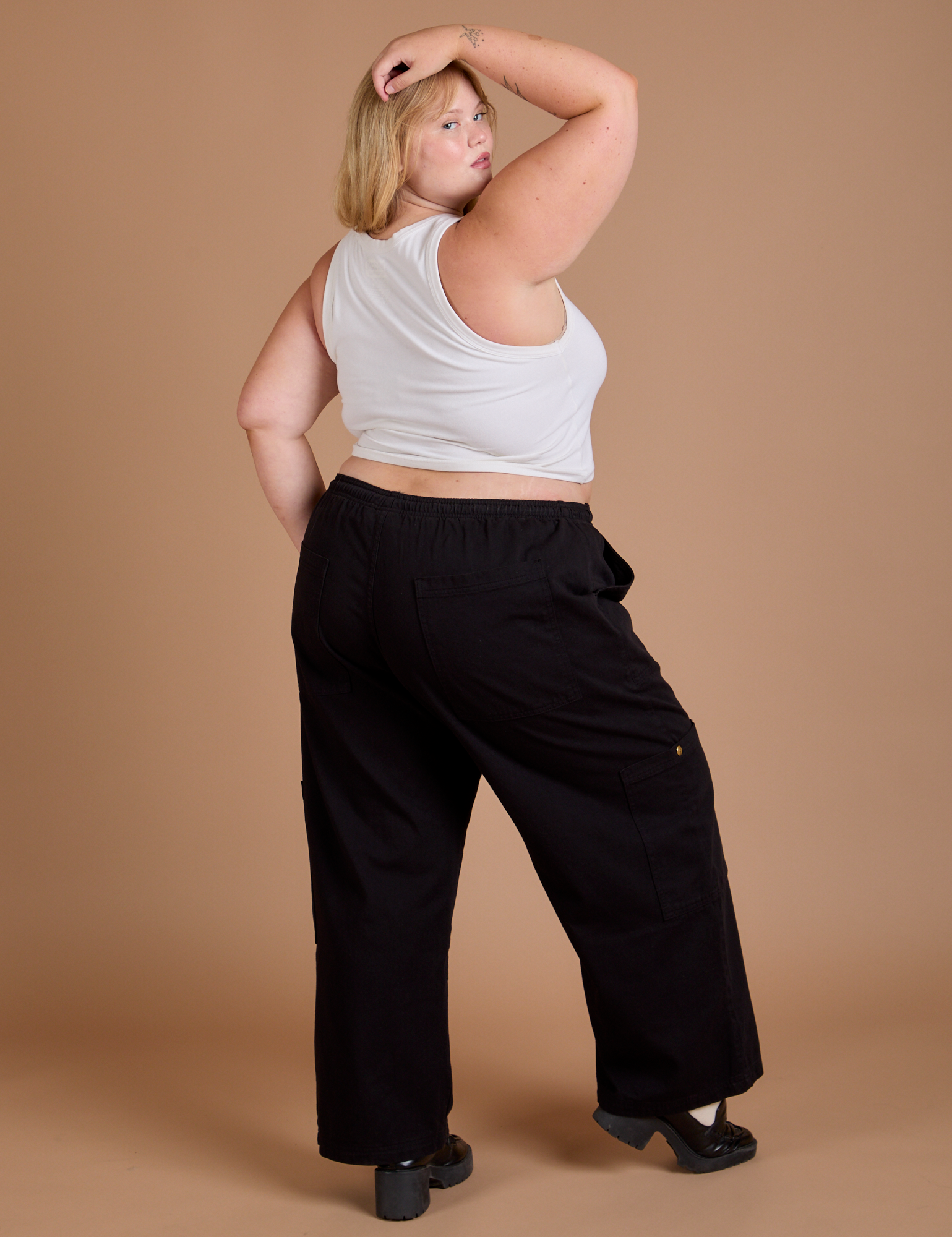 Angled back view of Drop Pocket Cargo Pants in Basic Black and Cropped Tank in vintage tee white on Juliet