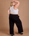 Angled back view of Drop Pocket Cargo Pants in Basic Black and Cropped Tank in vintage tee white on Juliet