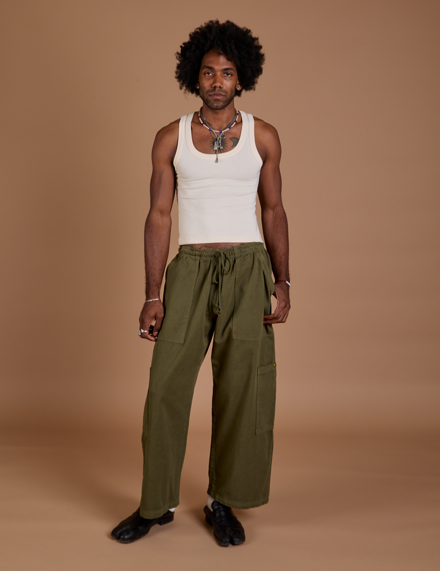 Jerrod is 6’3” and wearing M Drop Pocket Cargo Pants in Surplus Green paired with a Tank Top in vintage tee white