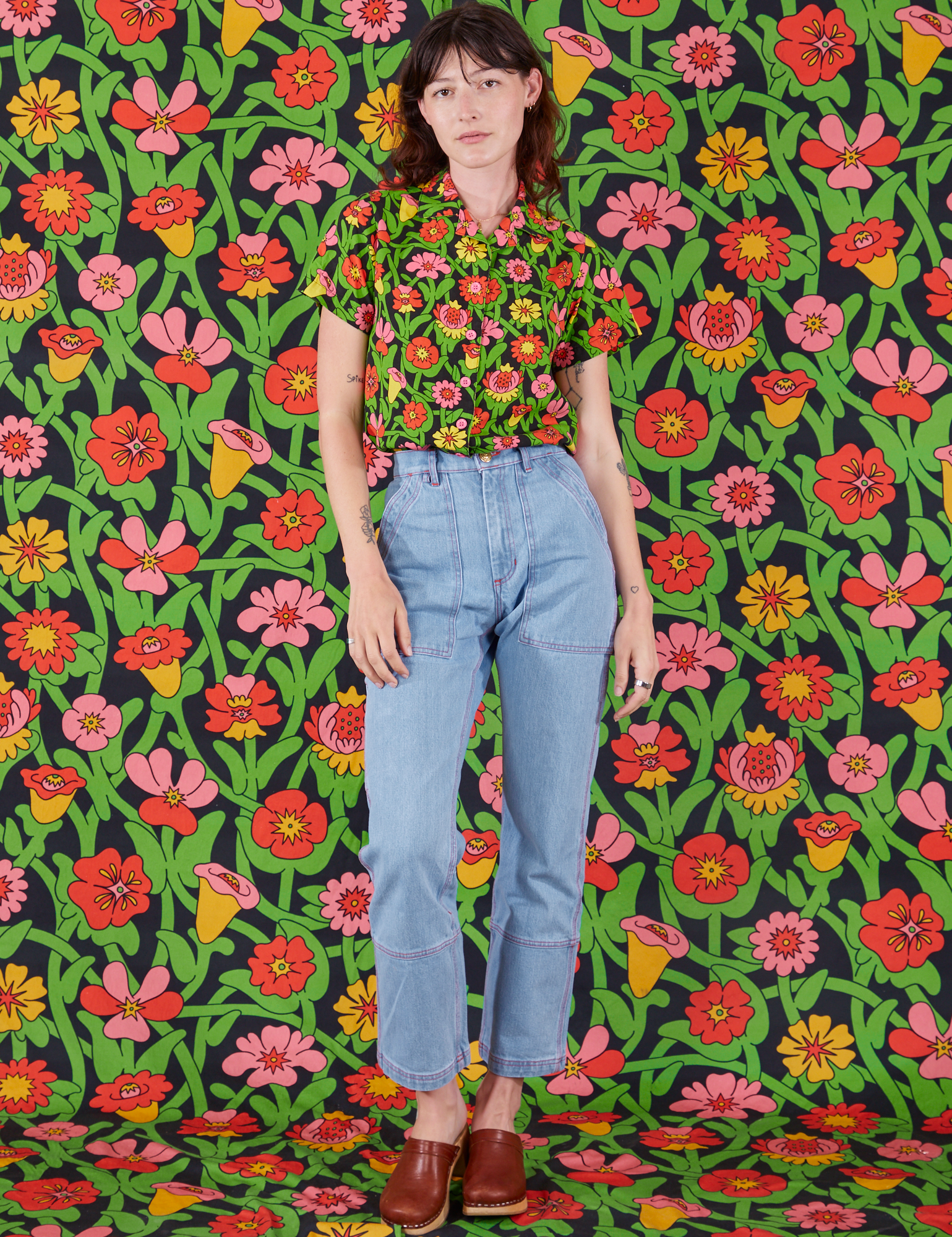 Alex is wearing Flower Tangle Pantry Button-Up tucked into light wash Carpenter Jeans