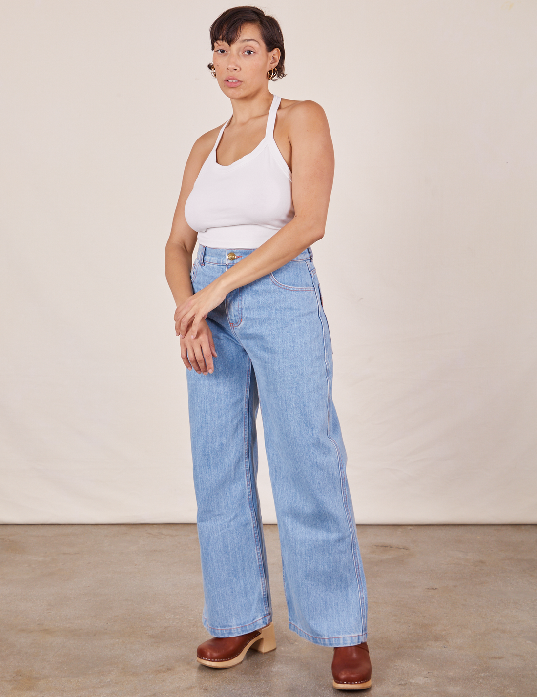 Tiara is wearing Halter Top in Vintage Off-White and light wash Sailor Jeans
