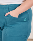 Cropped Rolled Cuff Sweatpants in Marine Blue front pocket close up. Marielena has her hand in the pocket.