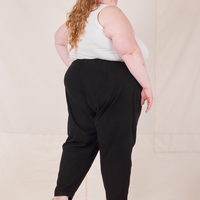 Angled back view of Heavyweight Trousers in Basic Black and vintage off-white Cropped Tank Top worn by Catie