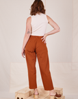 Back view of Heavyweight Trousers in Burnt Terracotta and vintage off-white Sleeveless Turtleneck worn by Alex